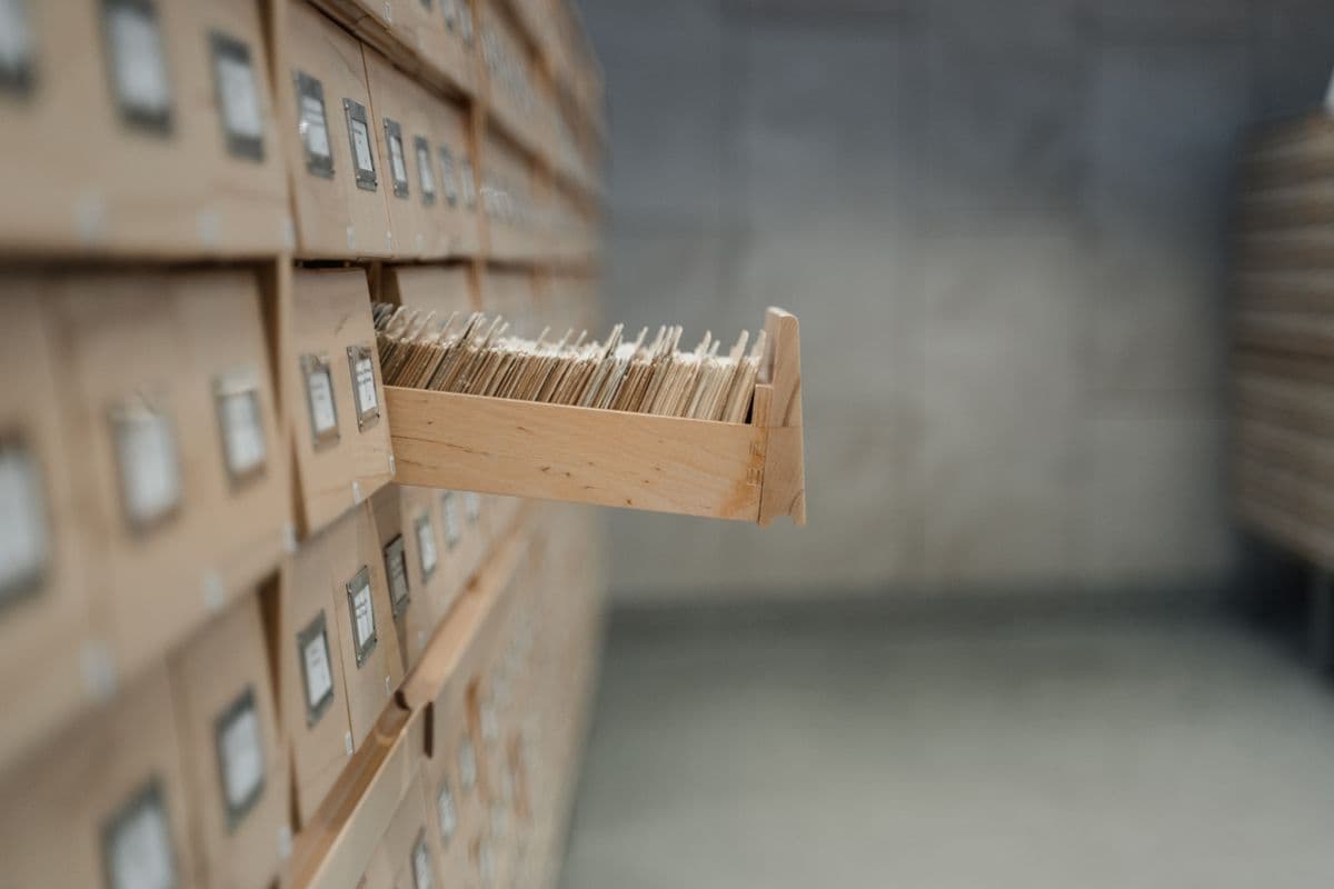 Uno schedario da biblioteca in legno con un cassetto aperto, le sue schede stipate in verticale