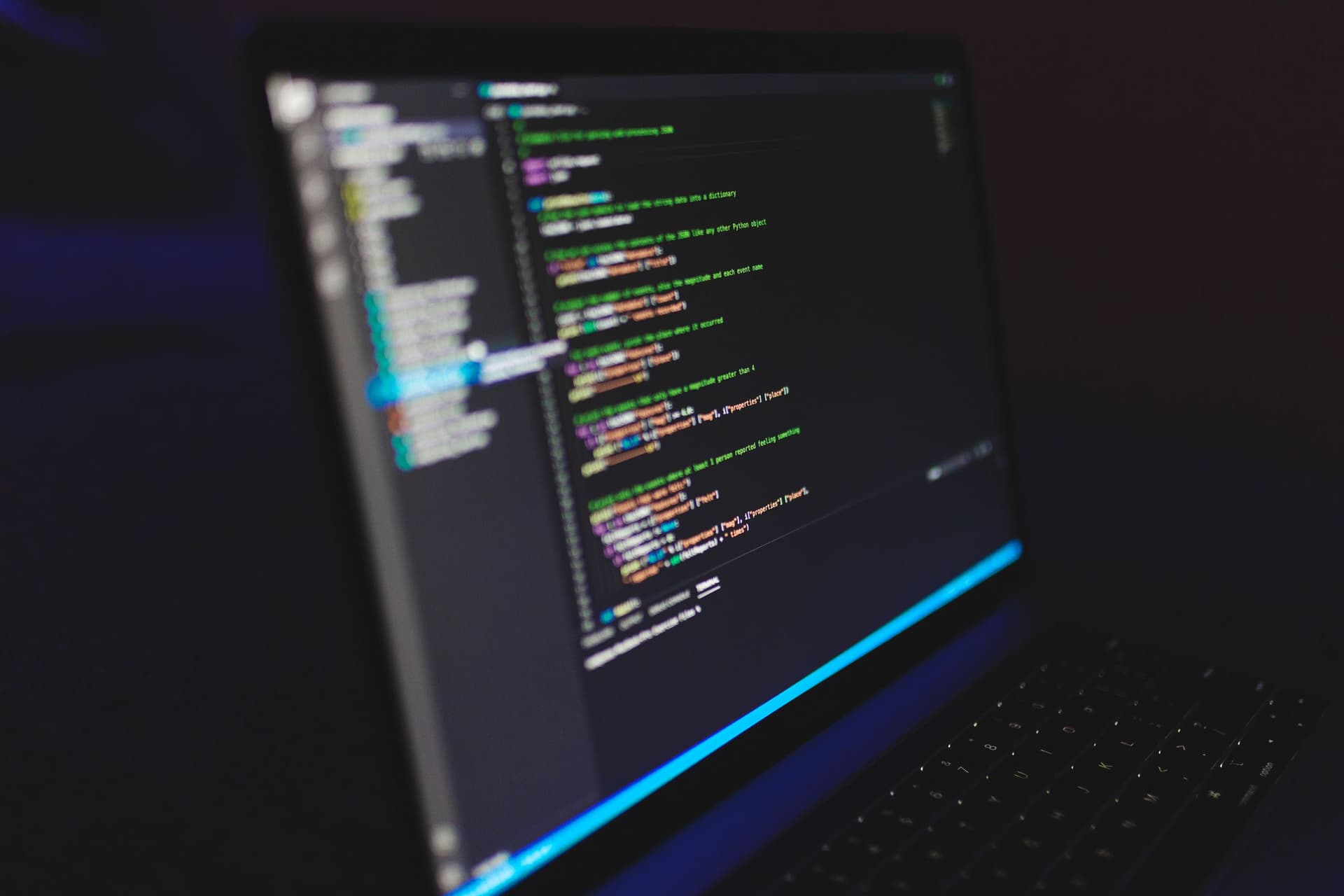 Un éditeur de code ouvert sur l'écran d'un portable dans une pièce sombre