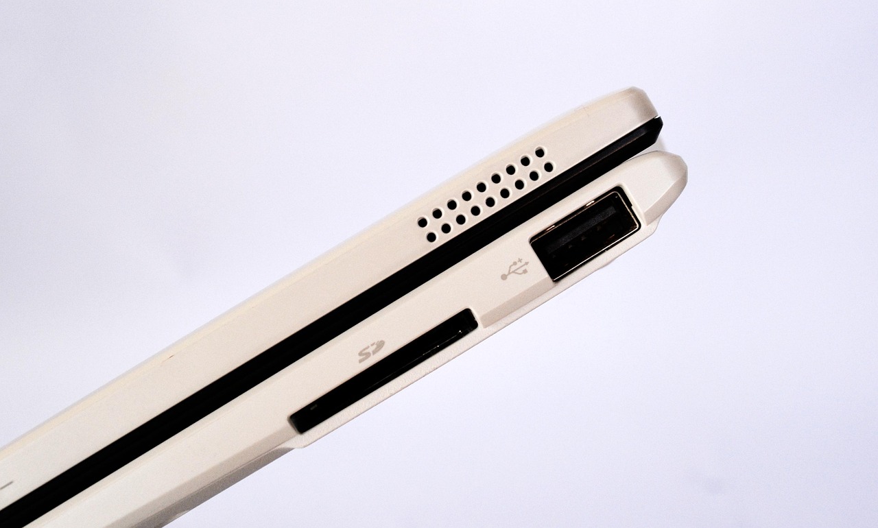A close-up of a laptop's side showing a USB port and an SD card slot, illustrating MCP as a universal connector for plugging tools into an AI