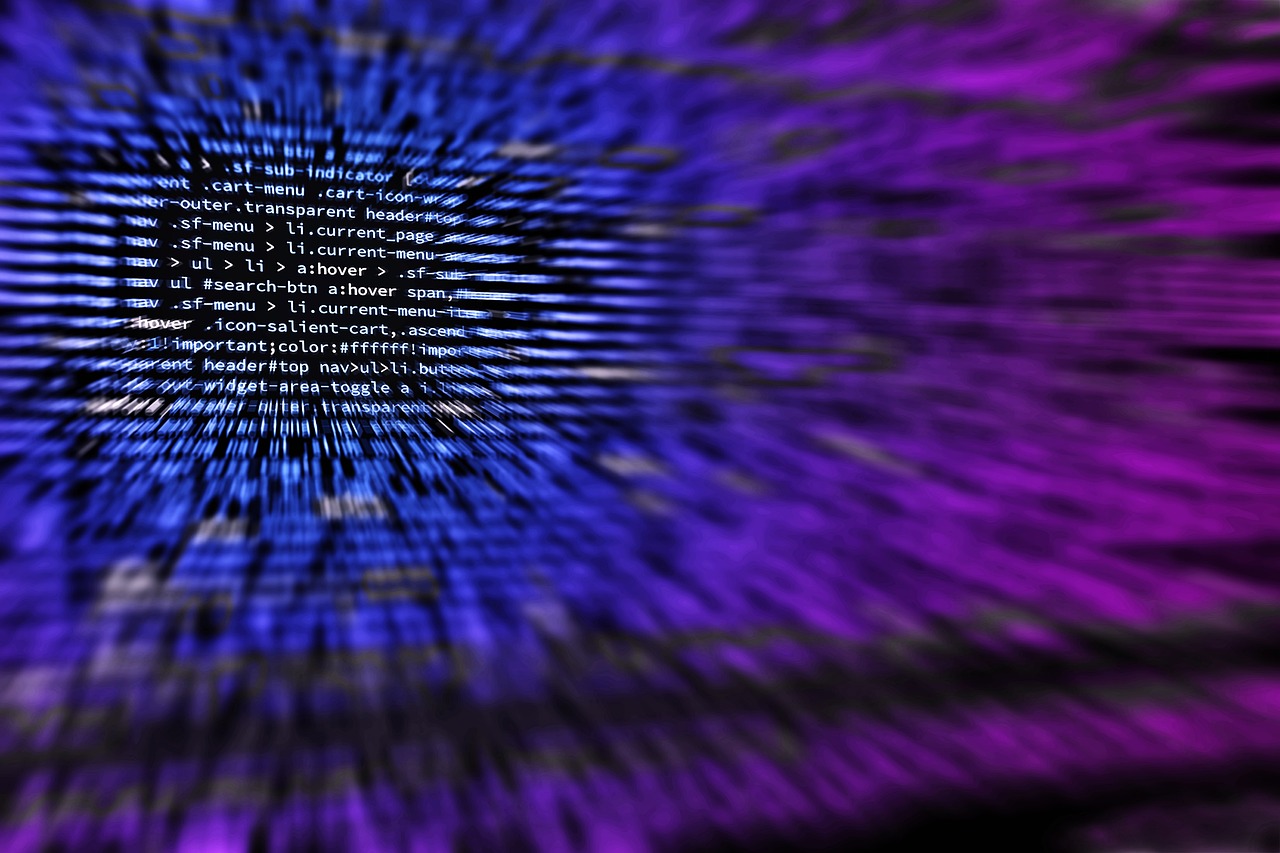 A developer typing at a keyboard in front of a screen full of code